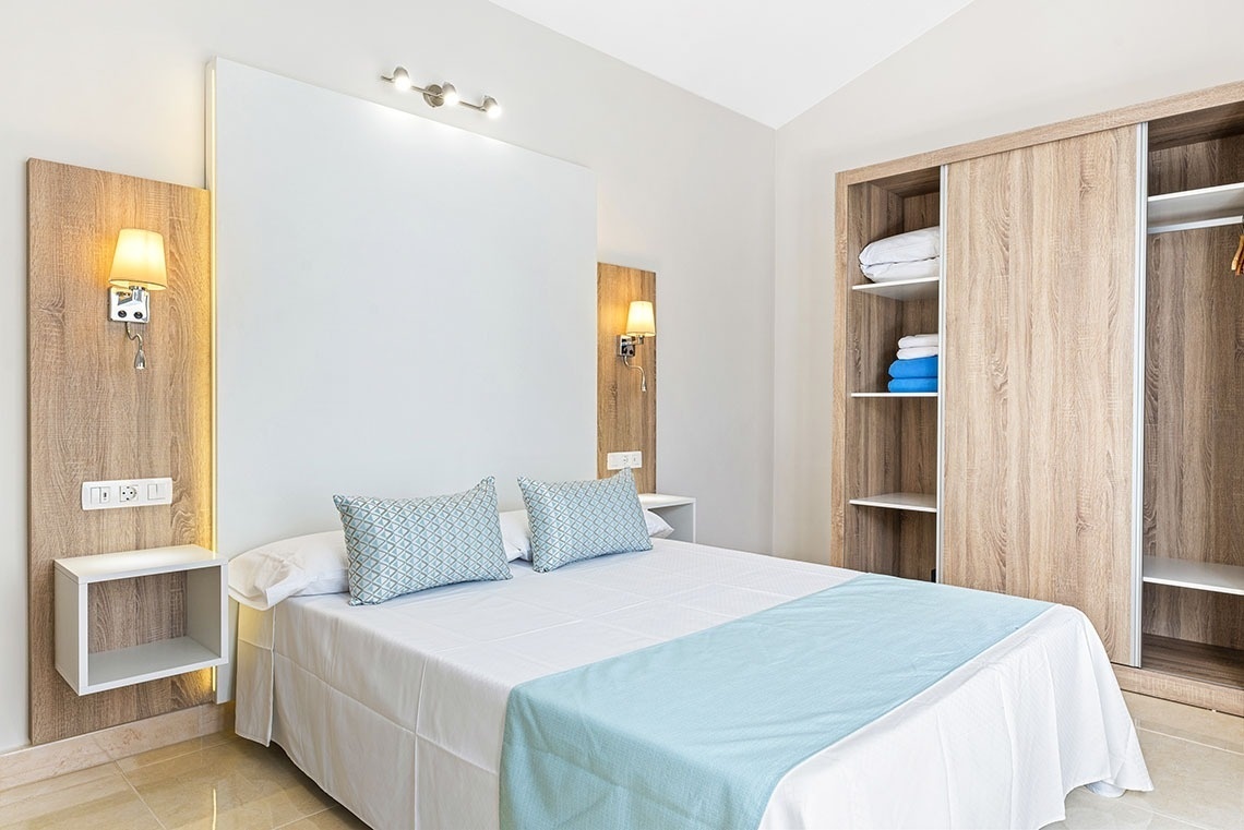 a bedroom with a white bed and blue pillows