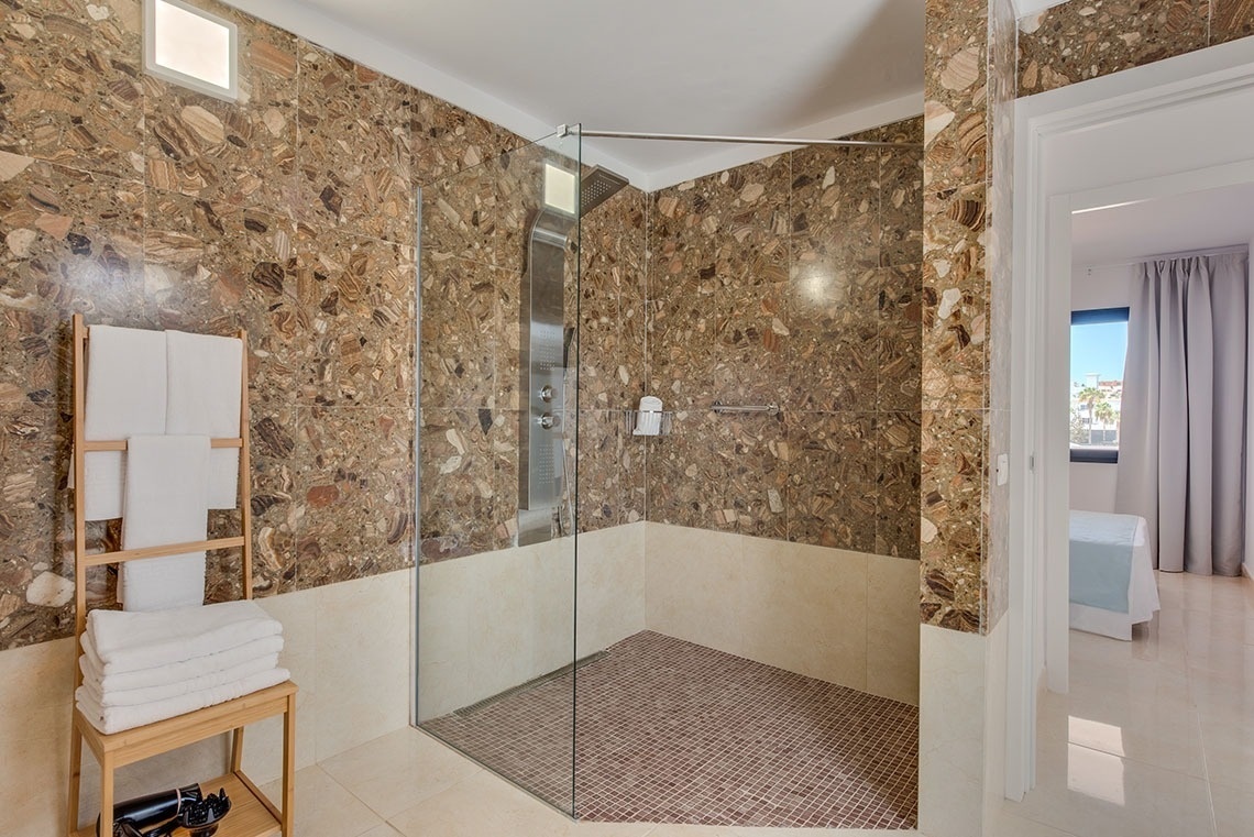a bathroom with a walk in shower and marble walls