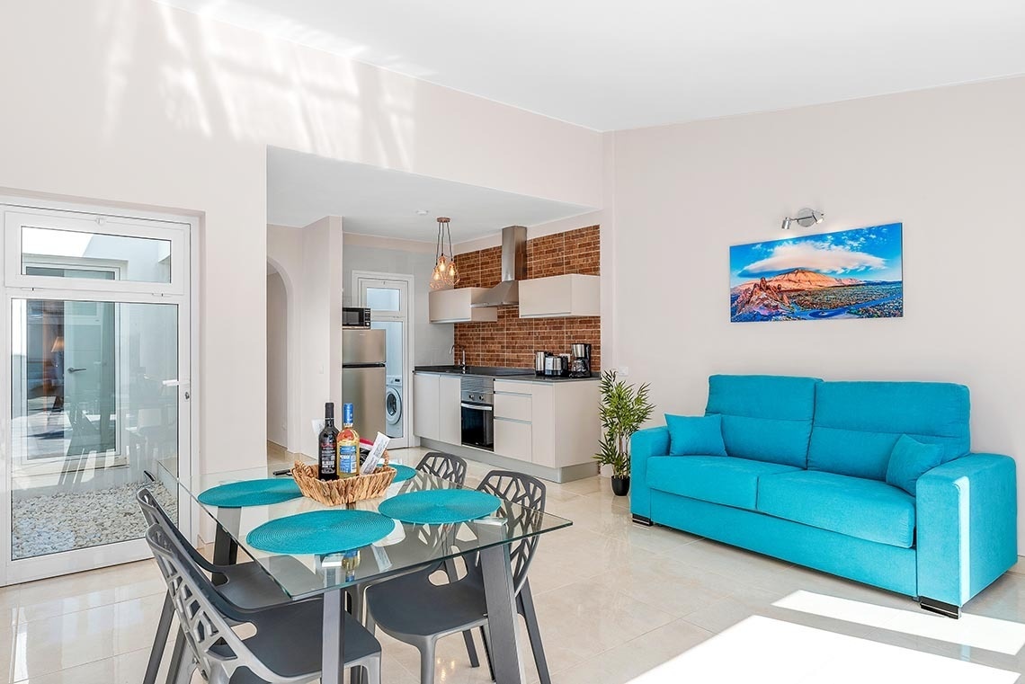 a living room with a blue couch and a painting on the wall