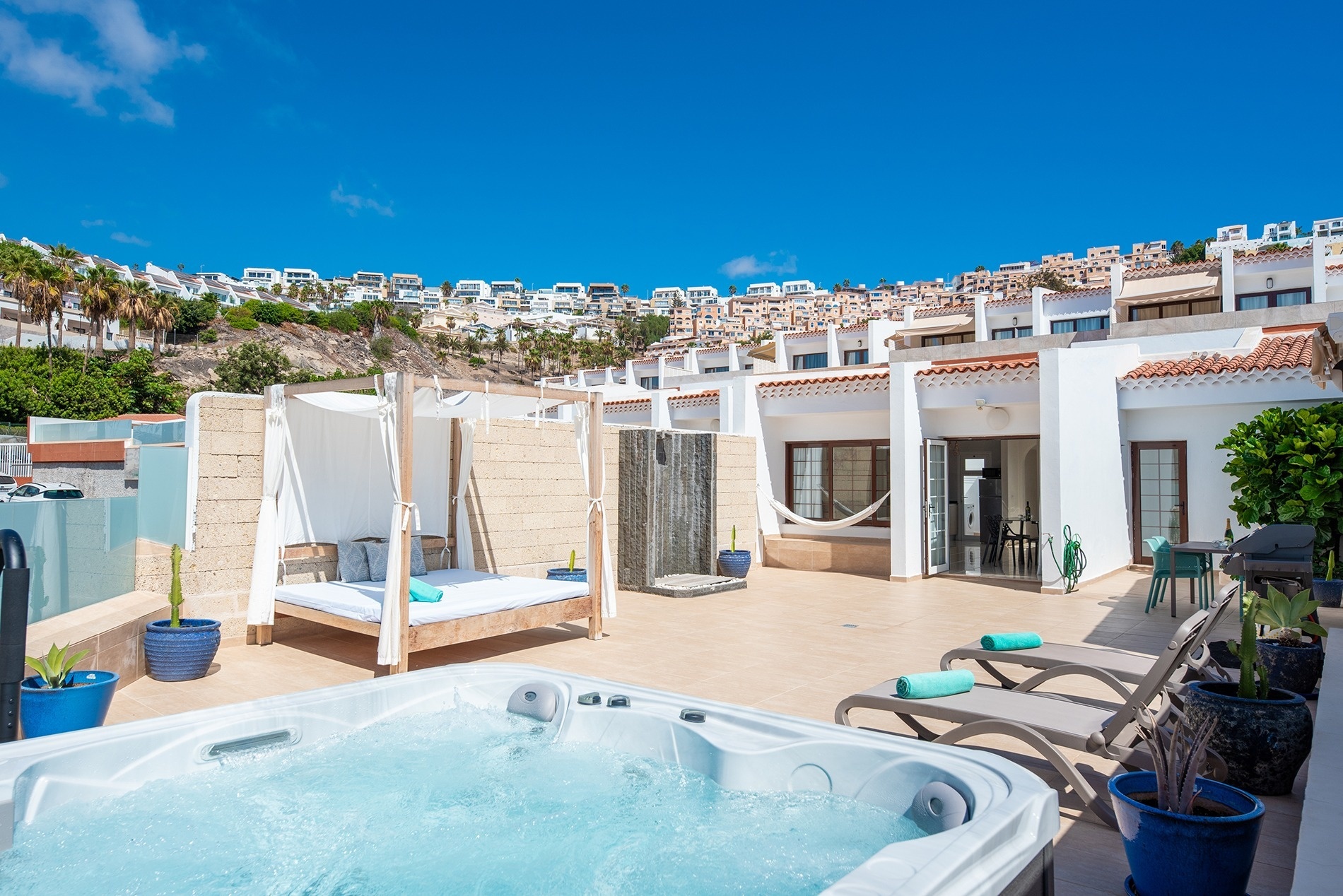 a patio with a table and chairs and a canopy bed