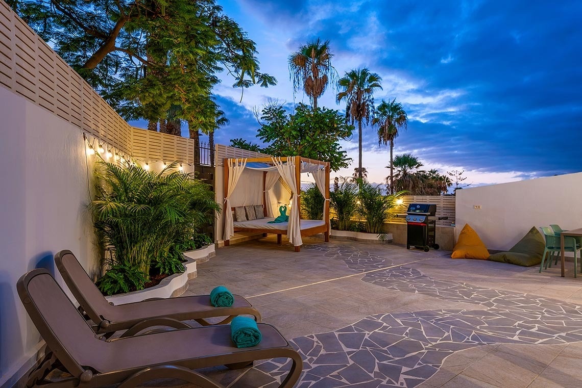 a patio area with a canopy bed and chairs