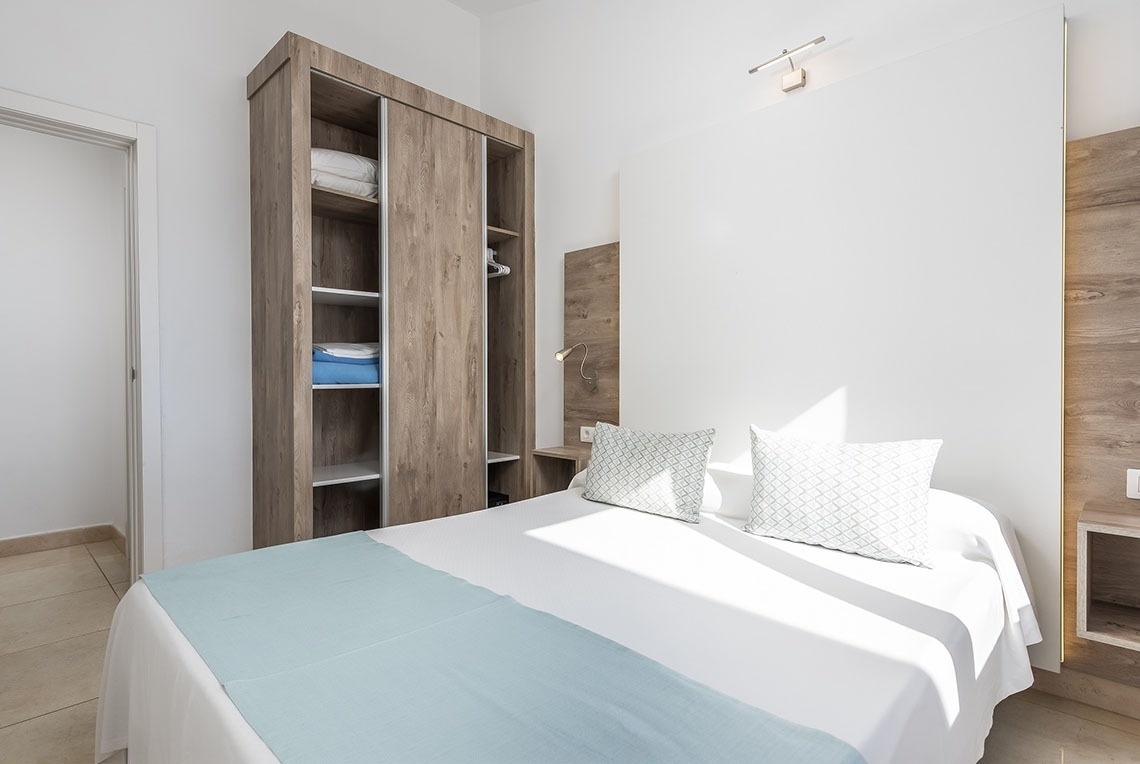 a bedroom with a bed and a closet filled with towels