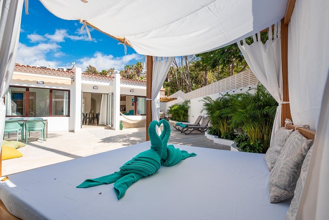 a canopy bed with two green towels on it