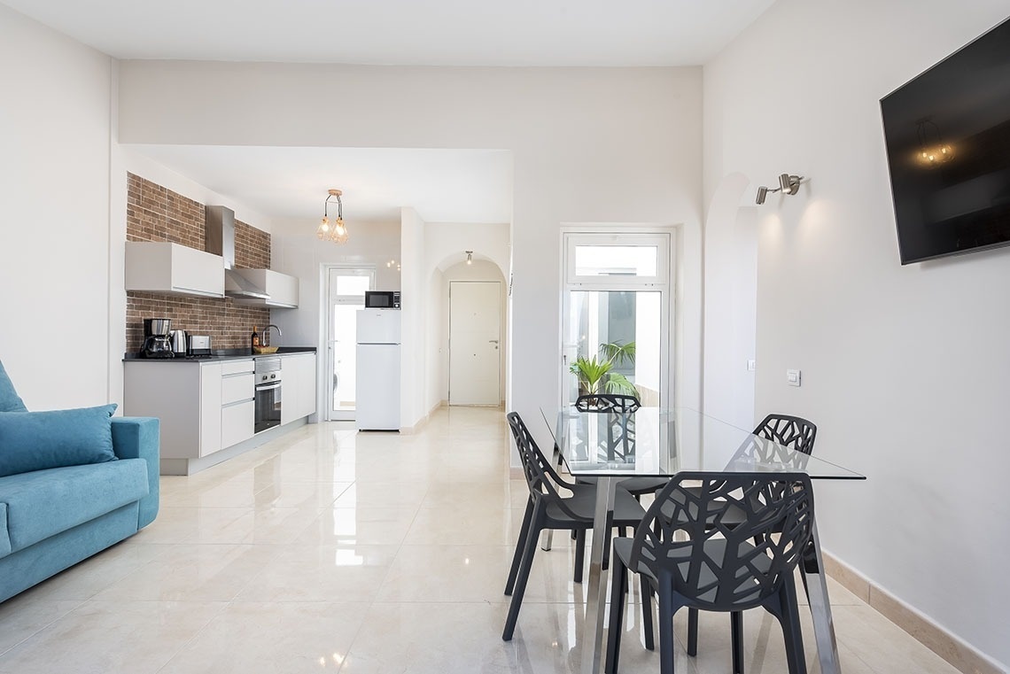 a living room with a table and chairs and a blue couch
