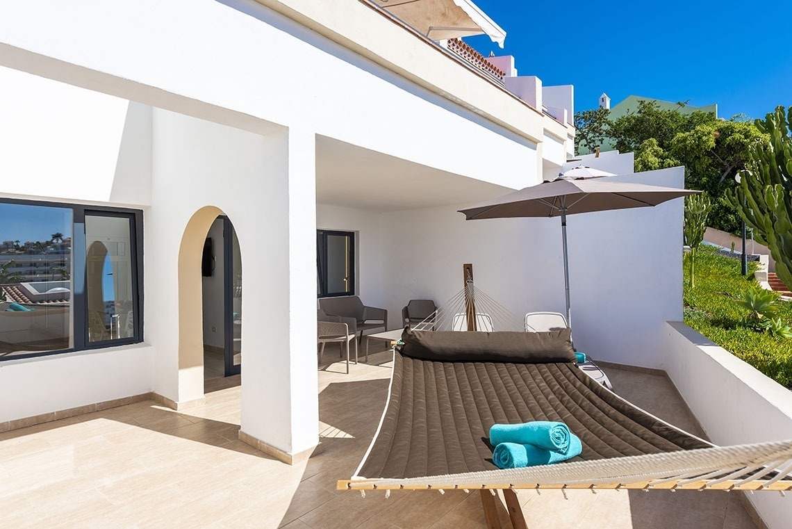 a hammock with two blue towels on it sits on a patio
