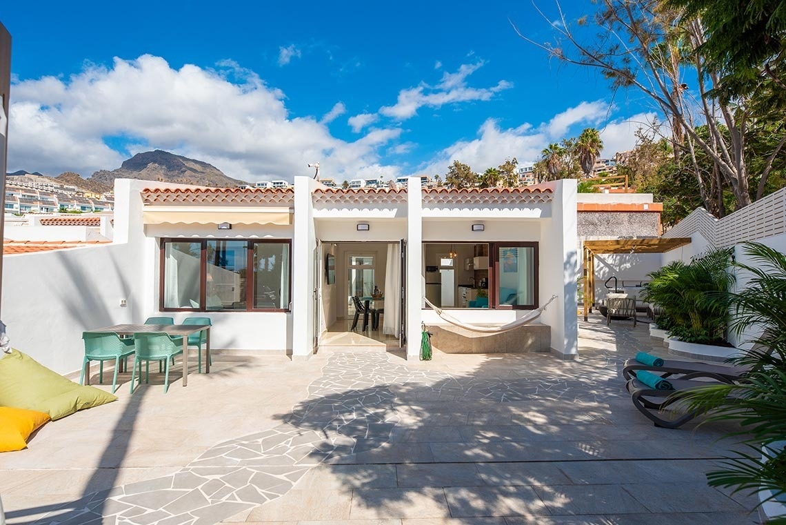 a white house with a hammock in the backyard