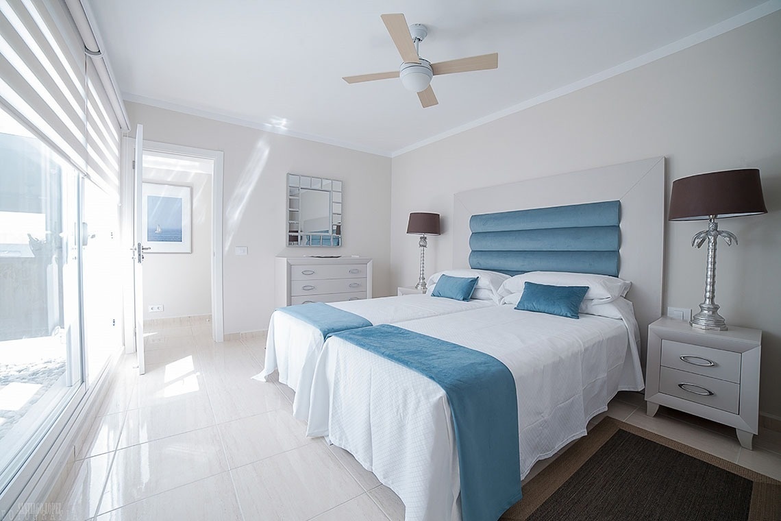 a bedroom with two beds and a ceiling fan