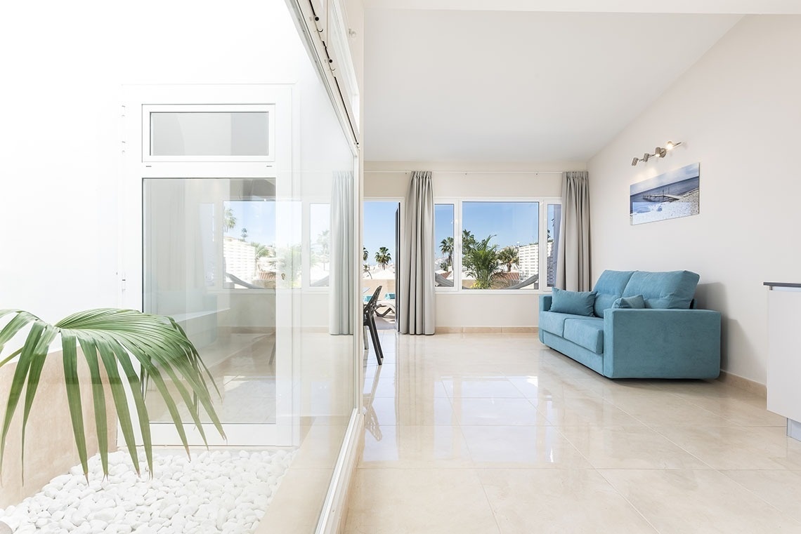 a living room with a blue couch and a picture on the wall