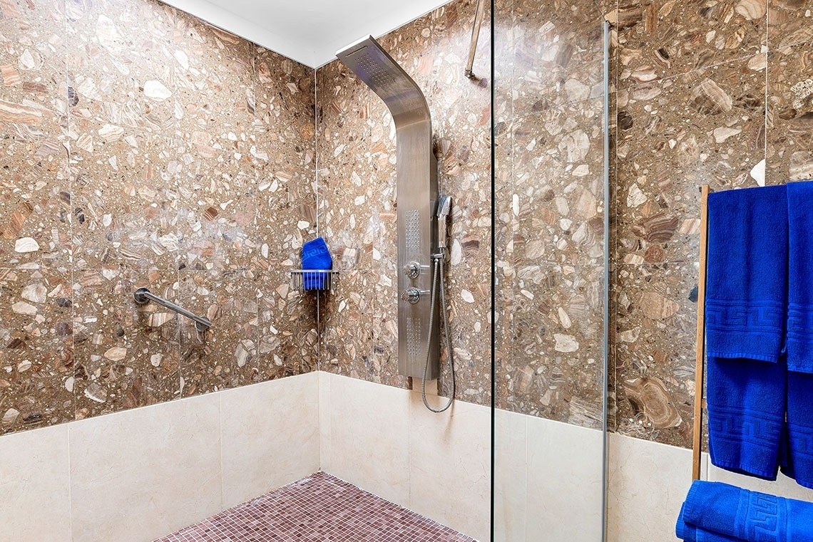 a bathroom with blue towels and a shower head