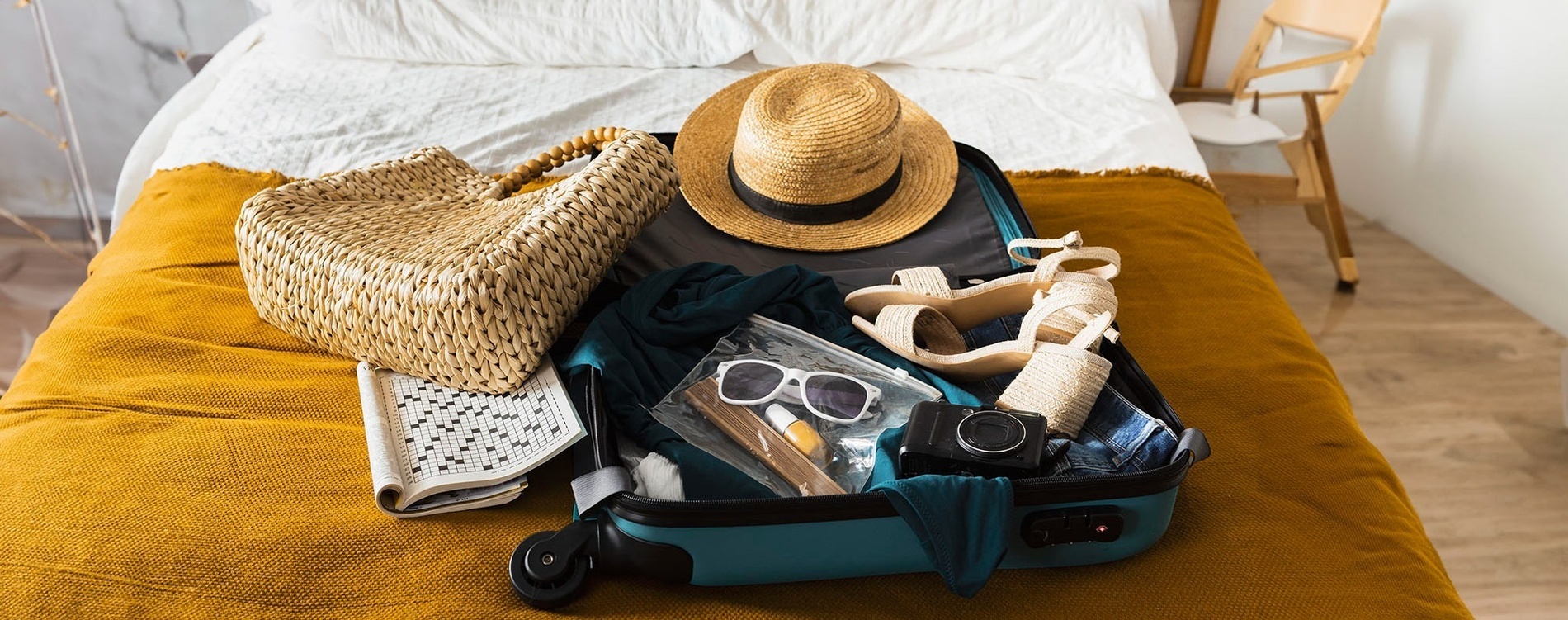 a woman sitting on a bench next to a suitcase looking at her phone