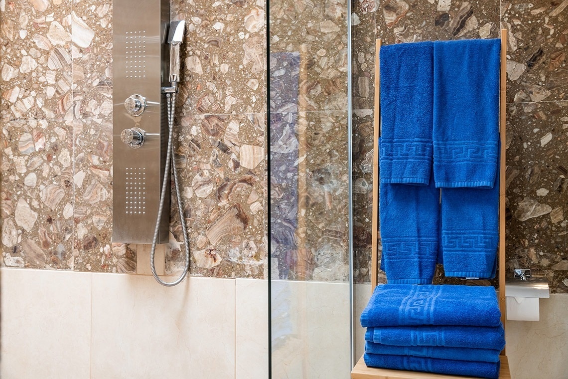 toallas azules en un estante de madera en un baño