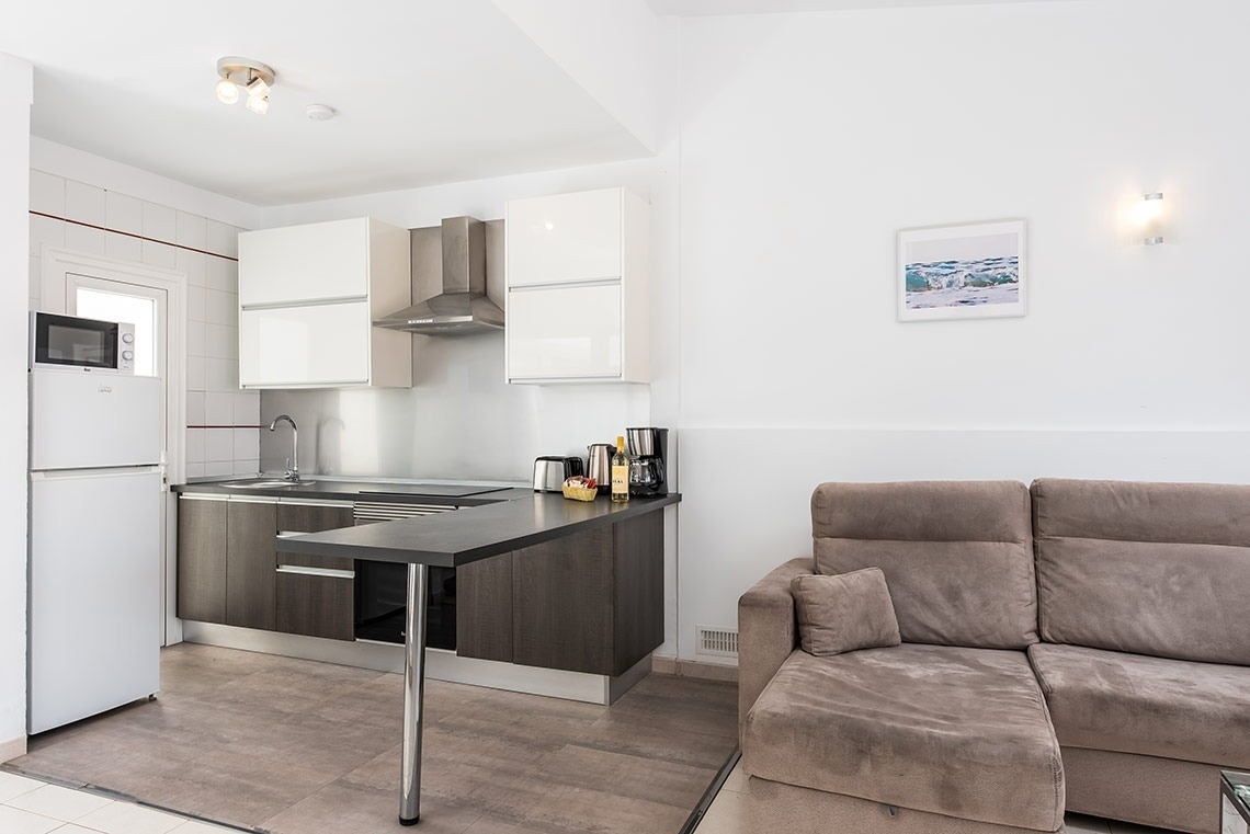 una cocina y una sala de estar con un sofá marrón