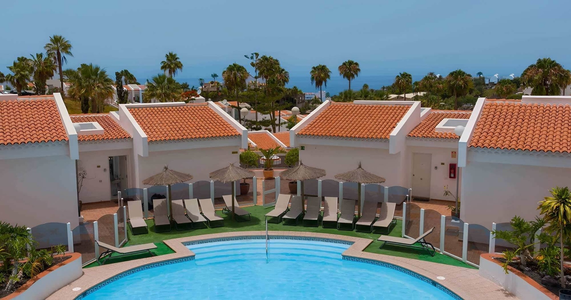 a large swimming pool surrounded by chairs and umbrellas