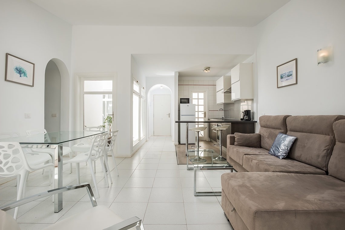 una sala de estar con un sofá marrón y una mesa de vidrio