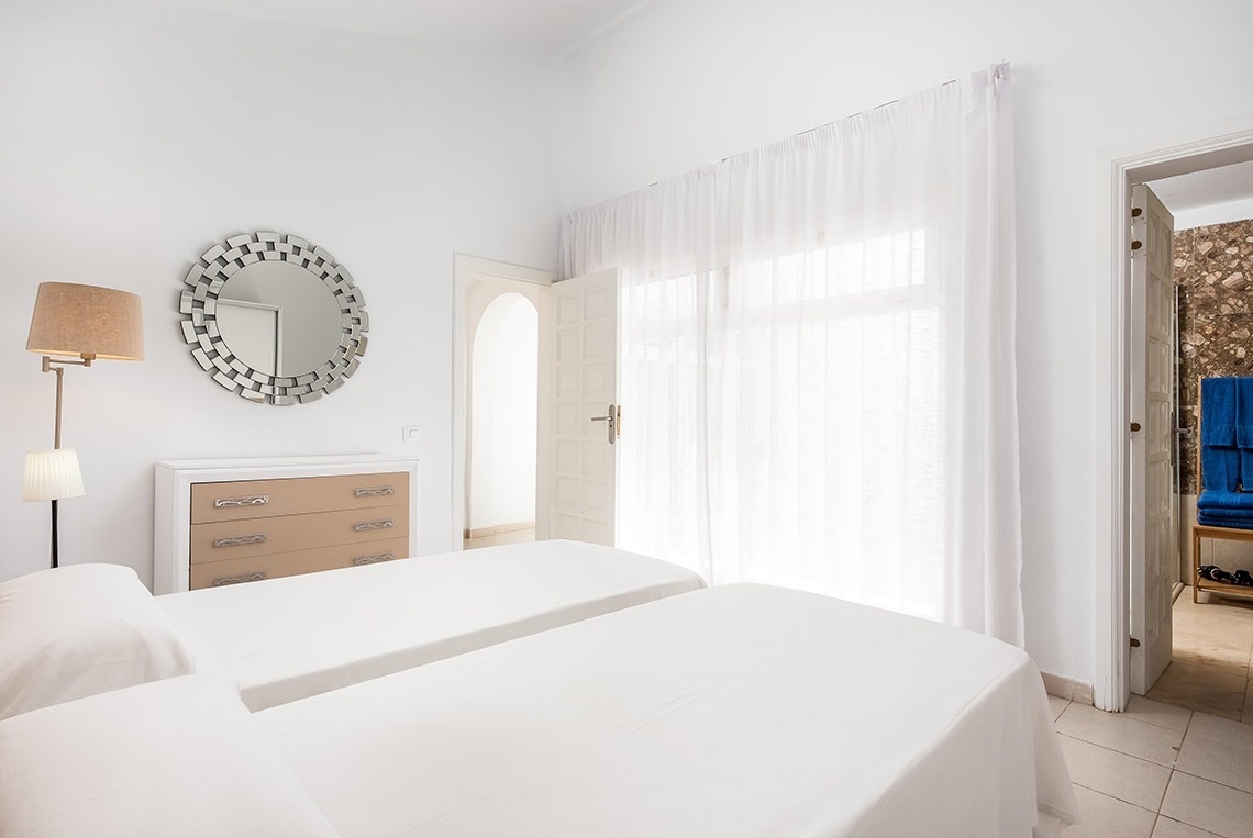 un dormitorio con dos camas y un espejo en la pared