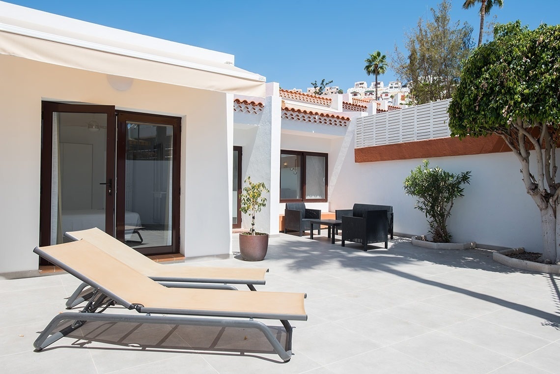 una hamaca con toallas y un paraguas en un balcón