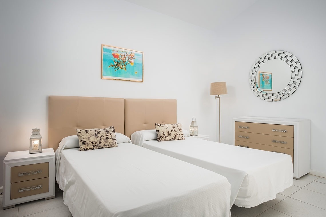 un dormitorio con dos camas y un espejo