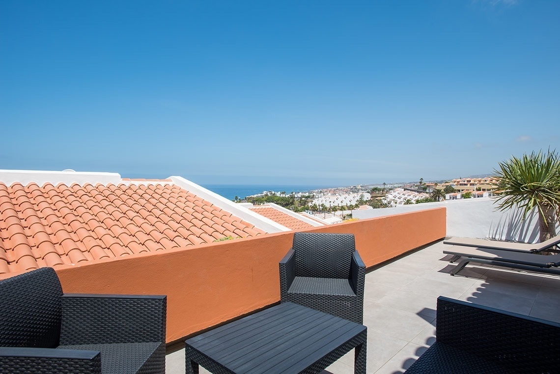 una terraza con sillas y una mesa con vistas al océano