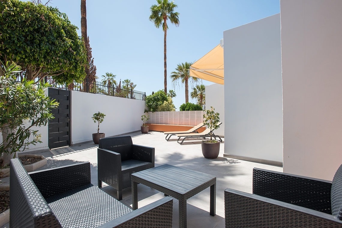 un patio con muebles de mimbre y una mesa