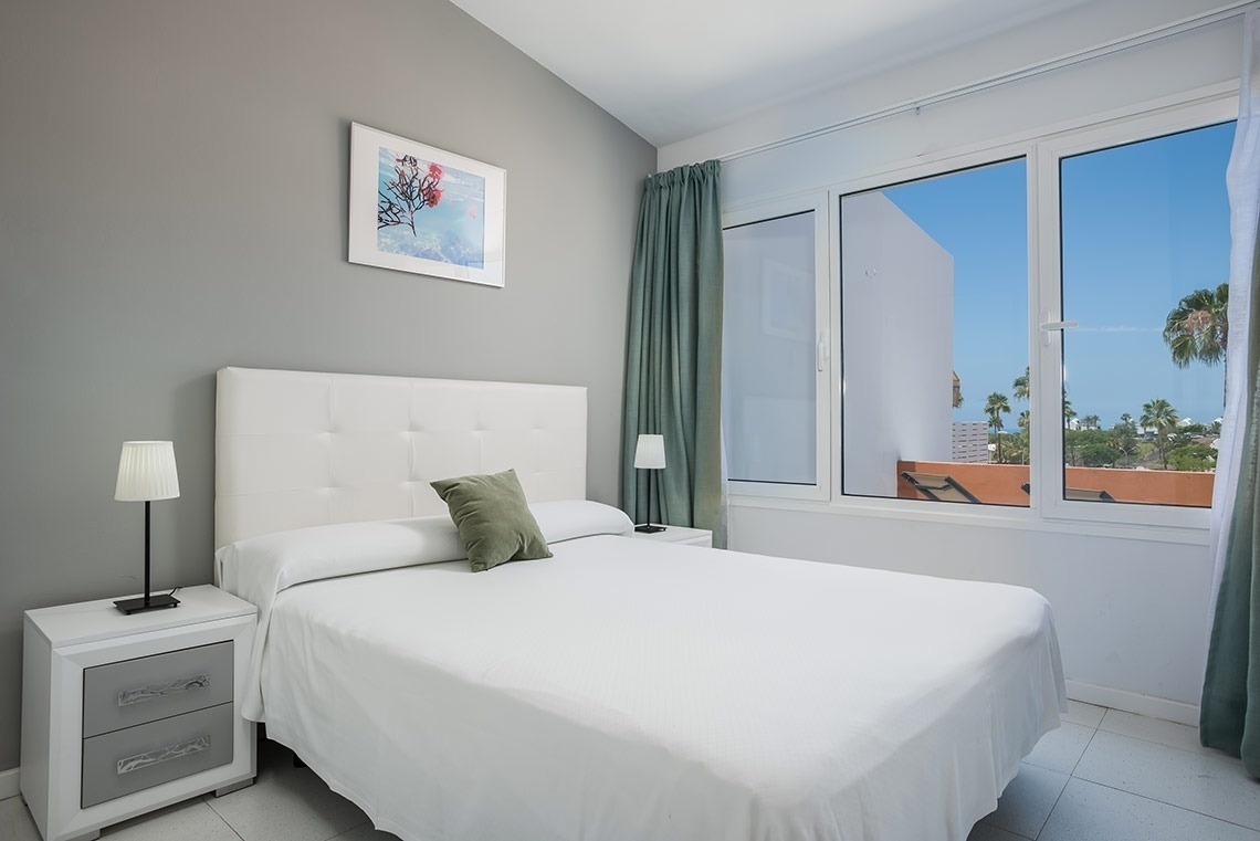 una hamaca con toallas y un paraguas en un balcón