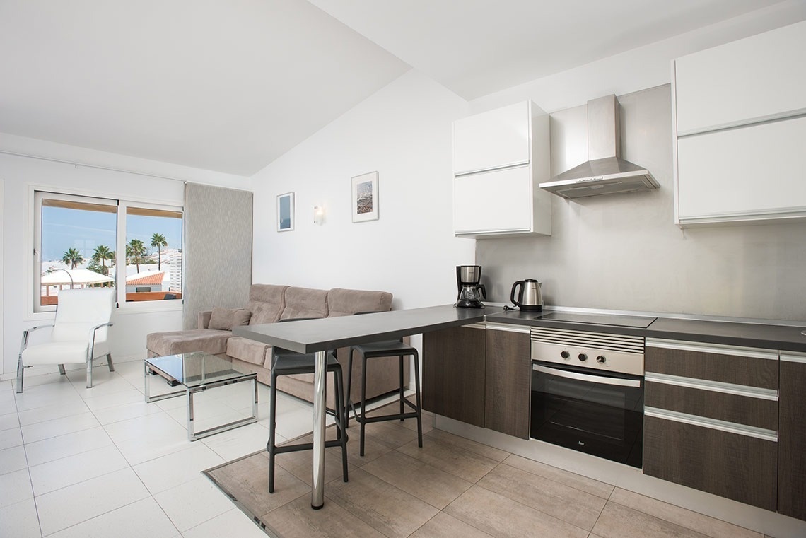 una cocina con una estufa de acero inoxidable y gabinetes de madera