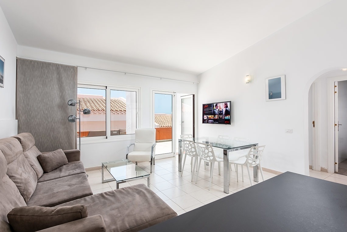 una sala de estar con un sofá y una mesa y sillas