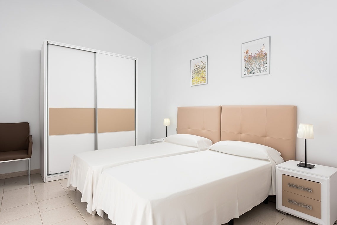 un dormitorio con dos camas y un armario