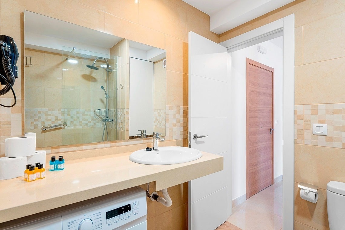 un bagno con lavatrice e lavandino e specchio