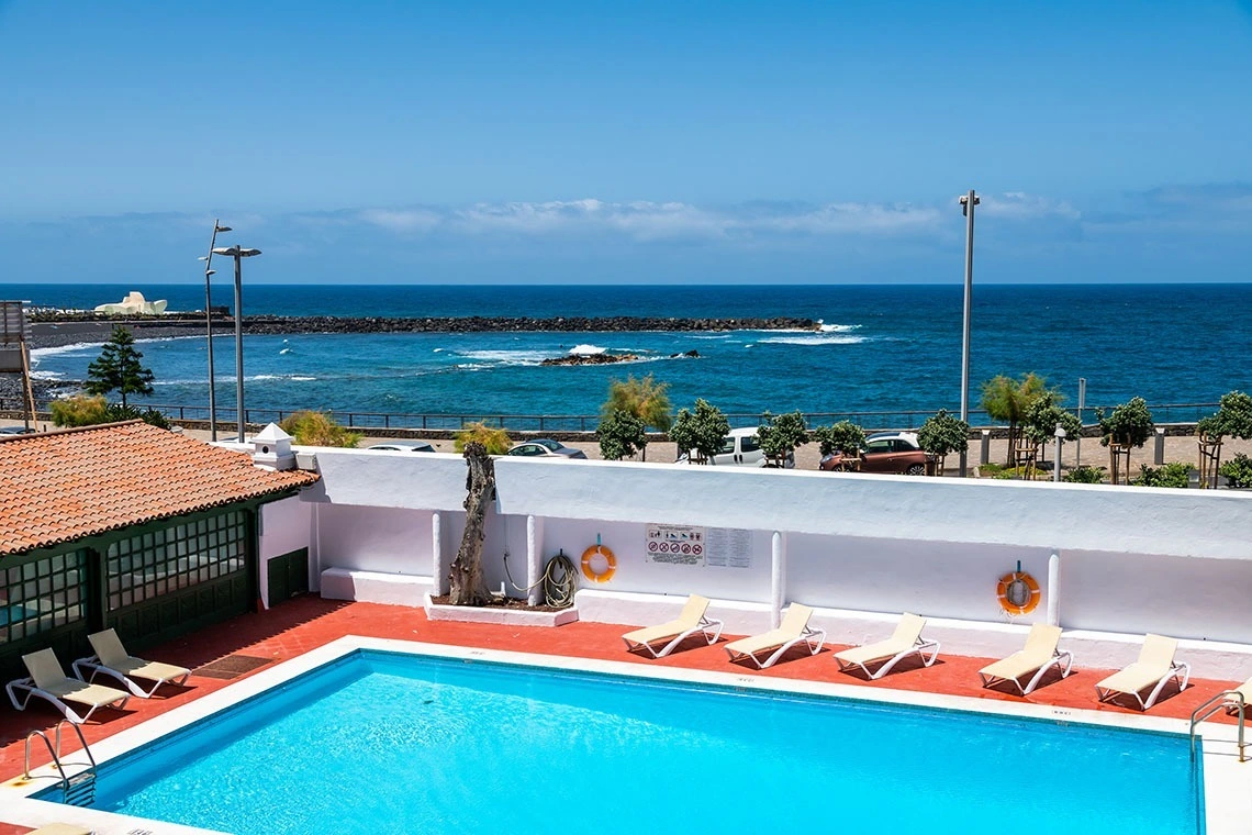 Piscina con vista mare a NEXUS: Ocean Vistas 24, lettini e sole.