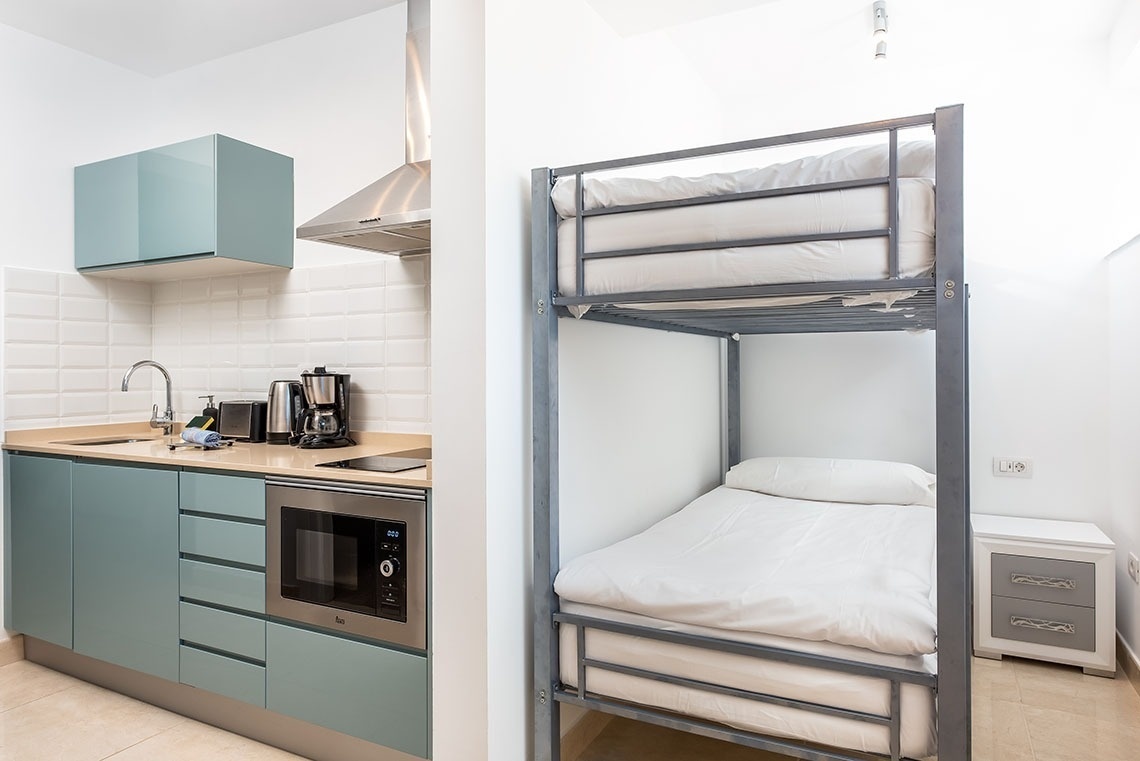 un letto a castello in una stanza accanto a una cucina