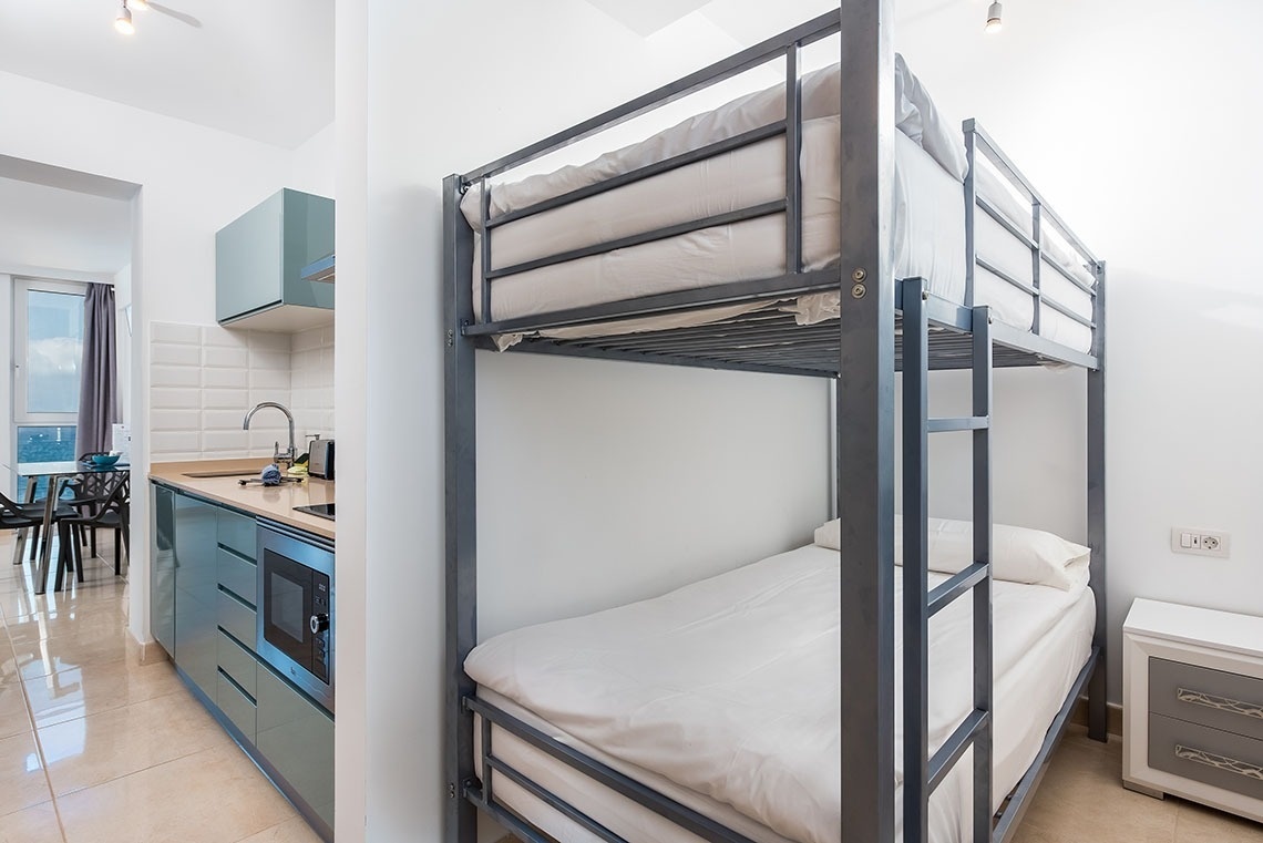 due letti a castello in una stanza accanto a una cucina