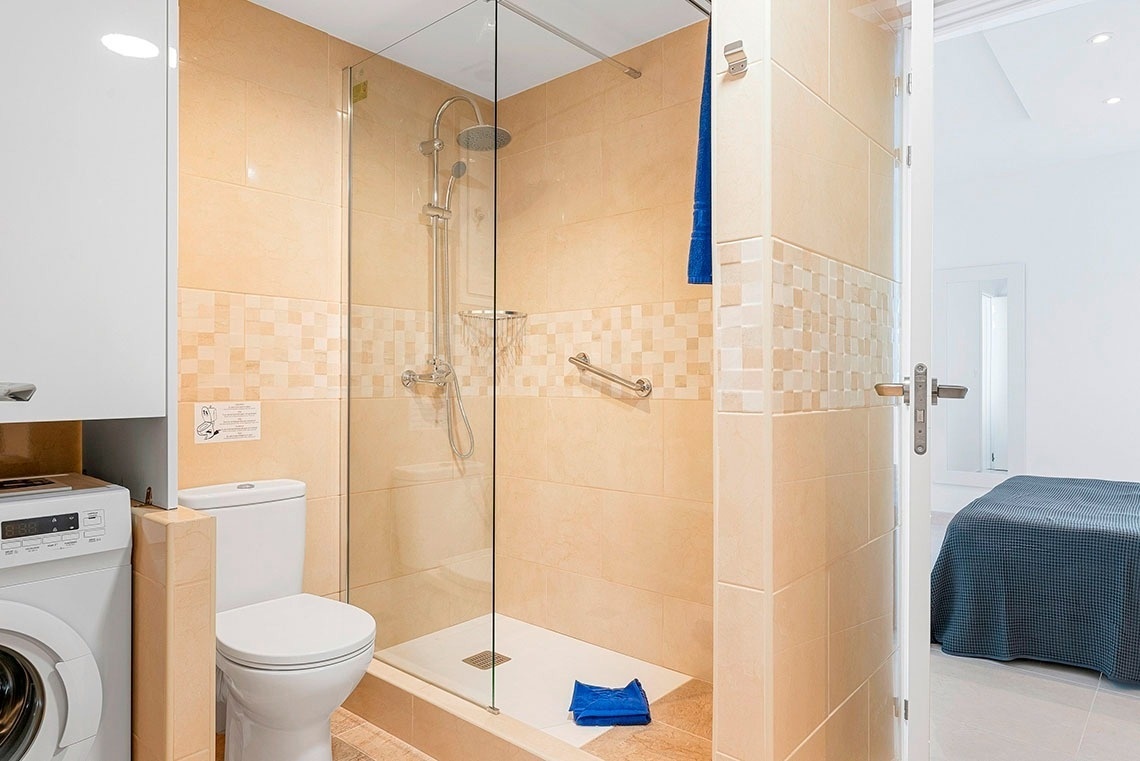 un bagno con doccia e wc e una lavatrice