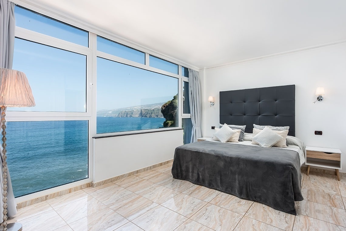 una camera da letto con un letto king size e una grande finestra con vista sull'oceano