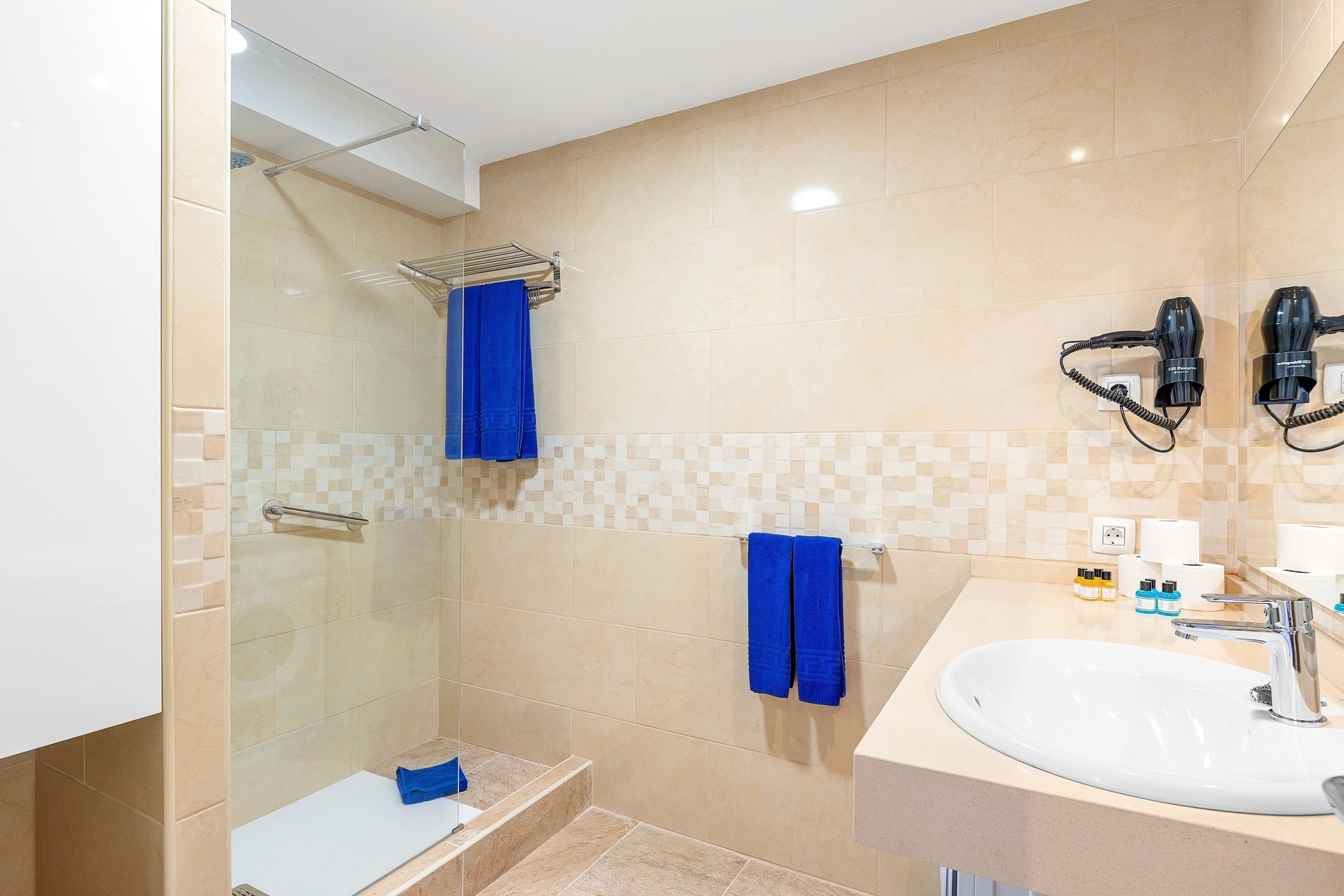 un bagno con doccia e lavandino e asciugacapelli