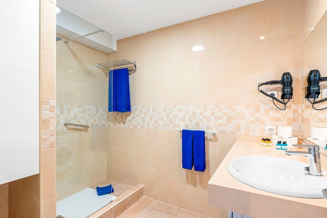 un bagno con doccia e lavandino e asciugacapelli