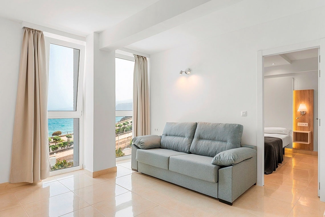 una stanza con un divano e una finestra con vista sull'oceano