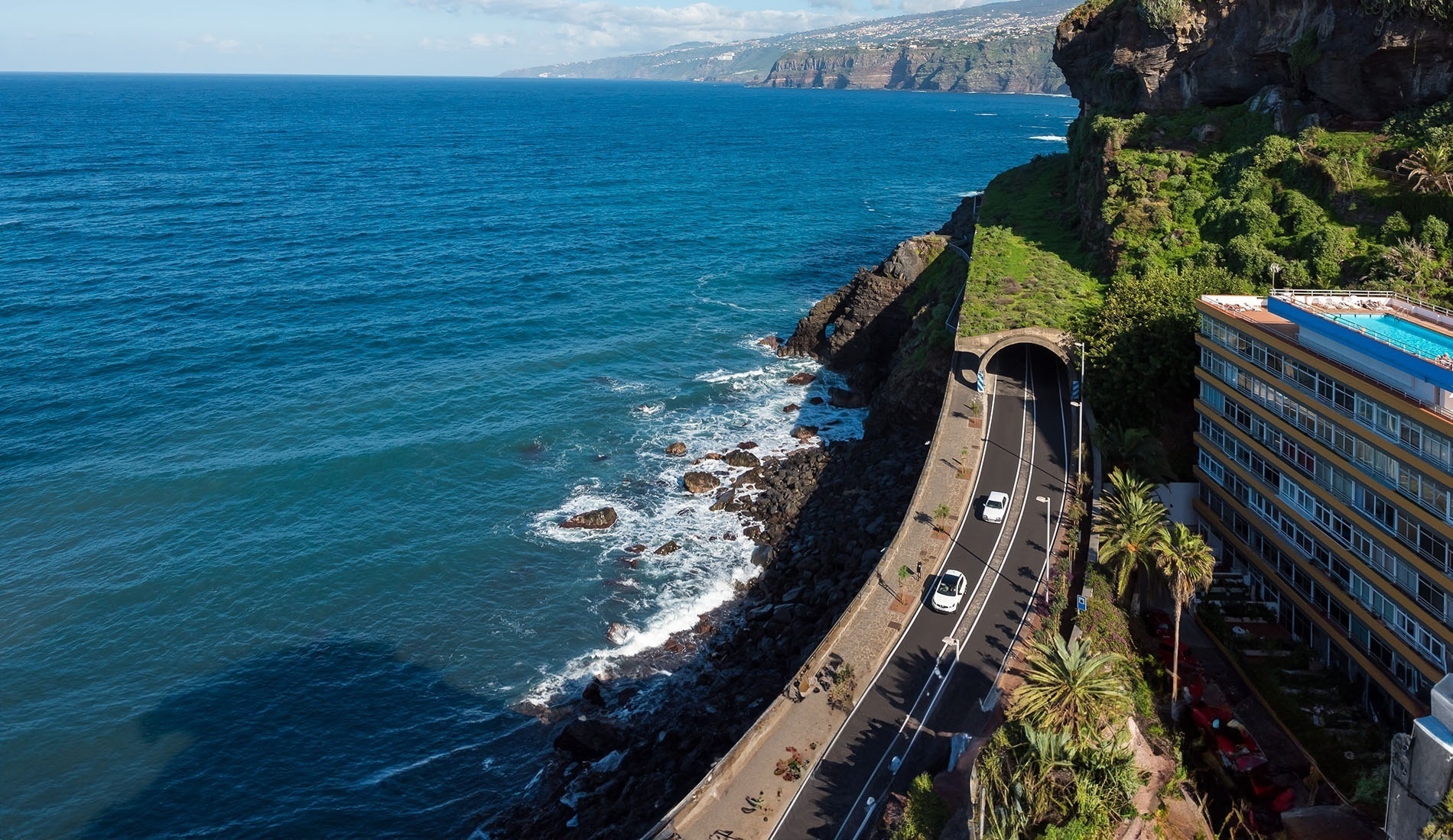 un balcón con sillas y hamaca al atardecer