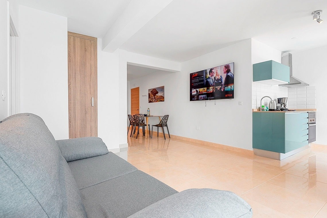 un soggiorno con un divano e un televisore che mostra netflix