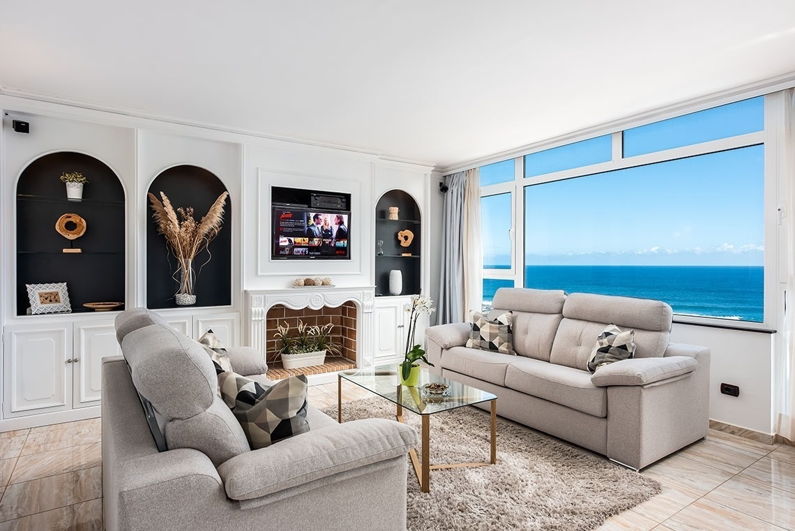 una stanza con un divano blu e una grande finestra