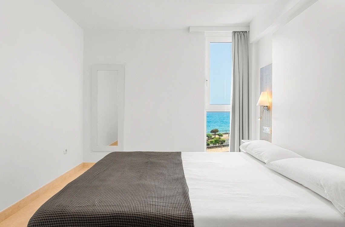 una camera da letto con un letto e una finestra con vista sull'oceano