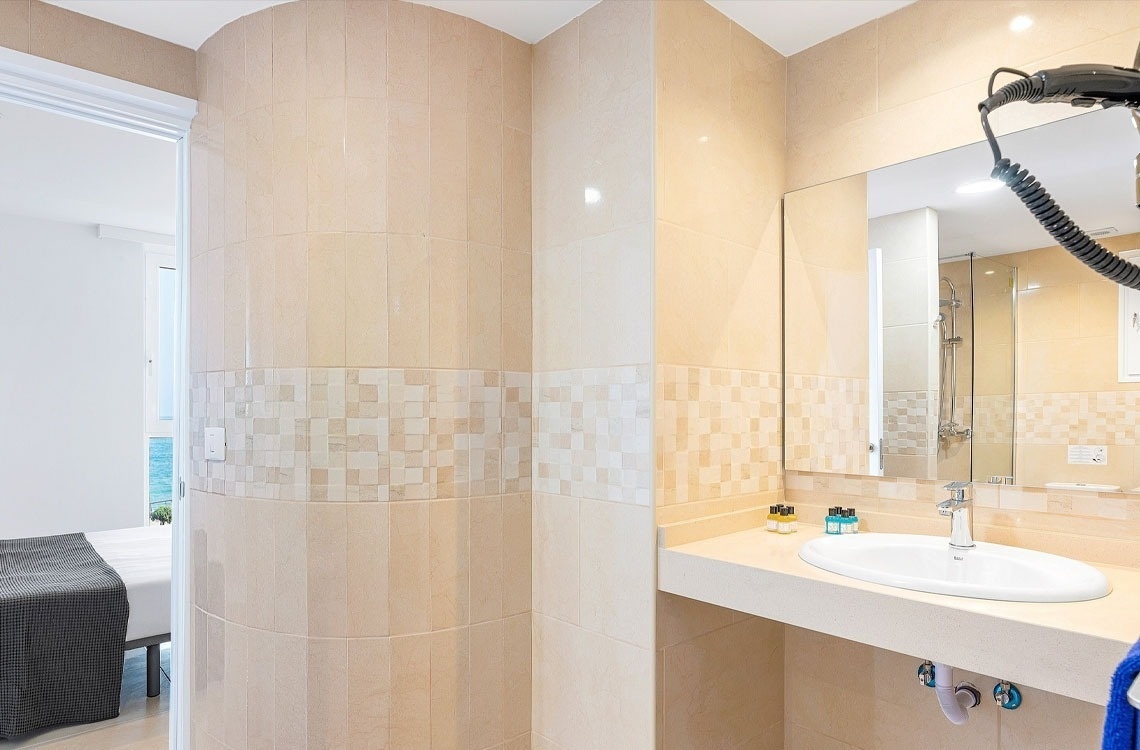 un bagno con lavandino e specchio e un asciugacapelli