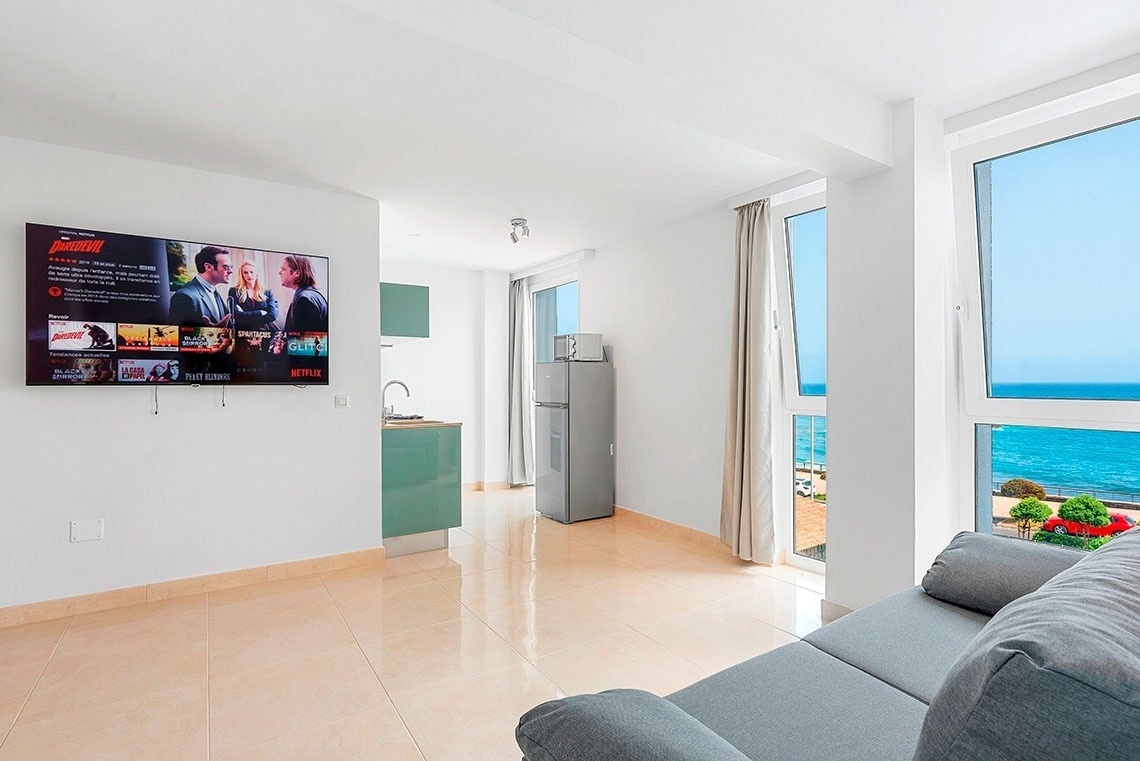 un soggiorno con un divano e un televisore che mostra netflix