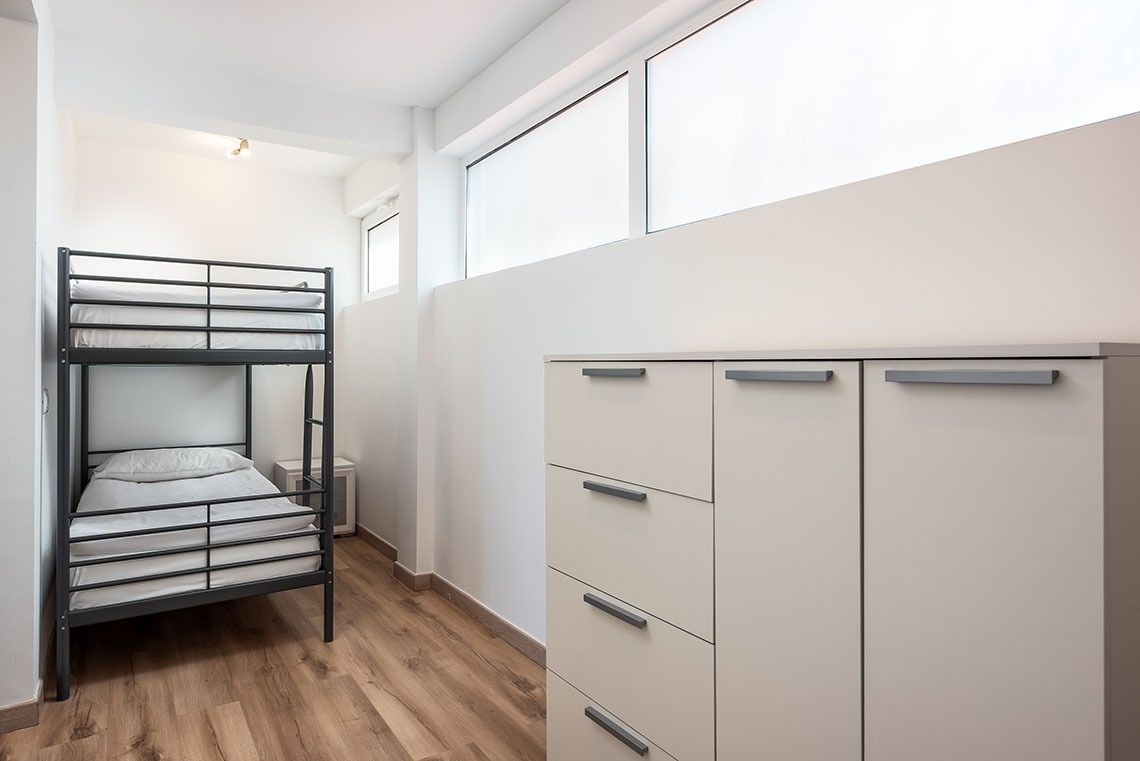 una stanza con un letto a castello e una cassettiera