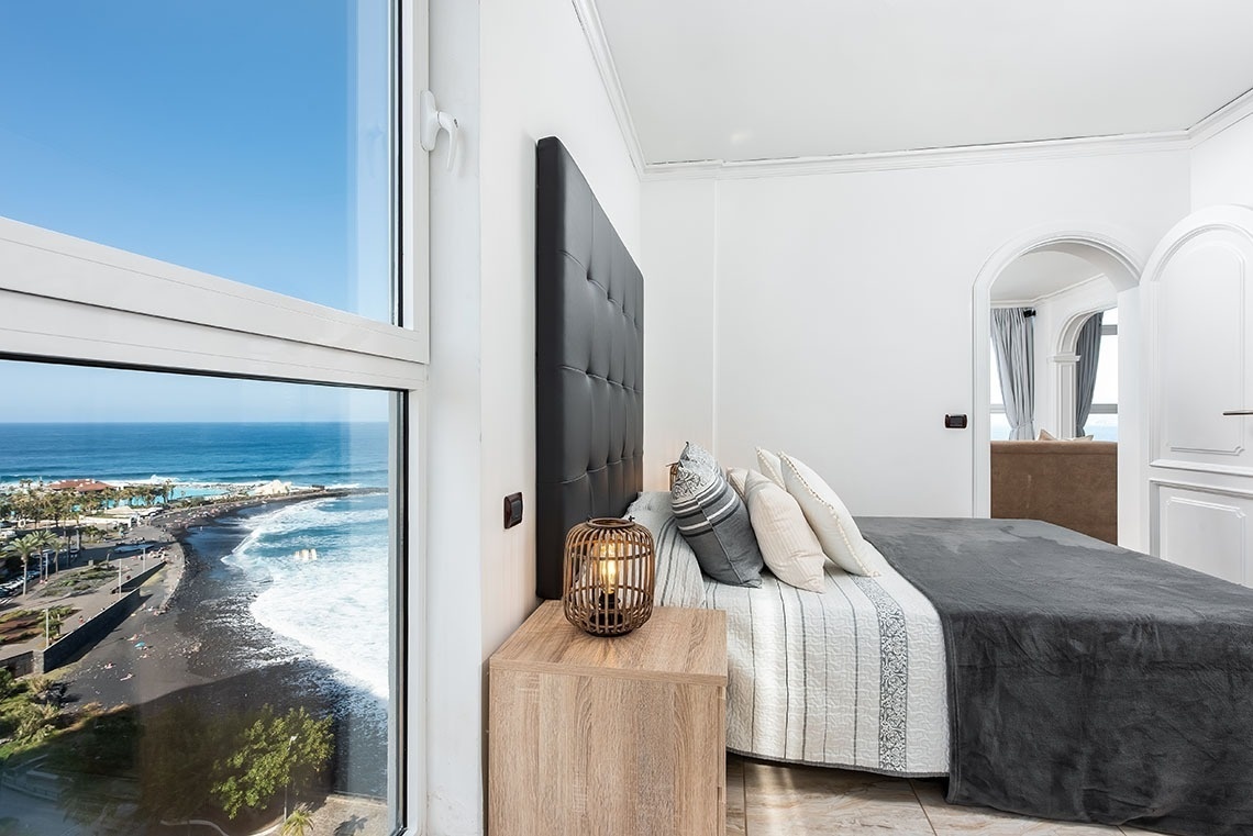 una camera da letto con un letto e una finestra che si affaccia sull'oceano