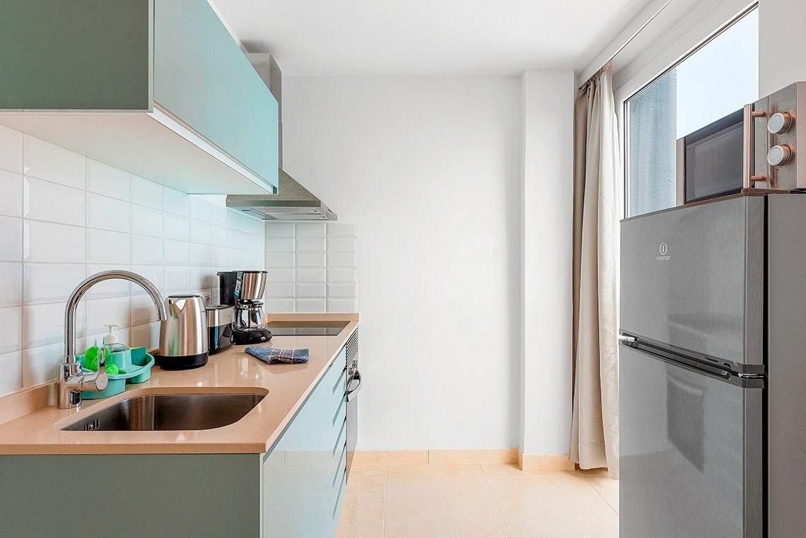 una cucina con un frigorifero indesit accanto a una finestra