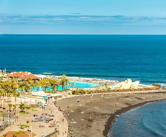 una hamaca y un paraguas en un balcón con vista al océano