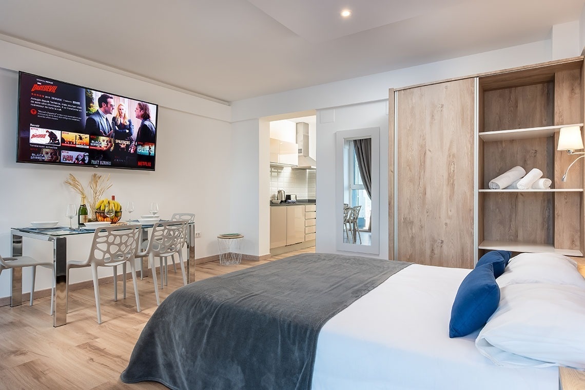 una stanza con un letto e un televisore che mostra netflix