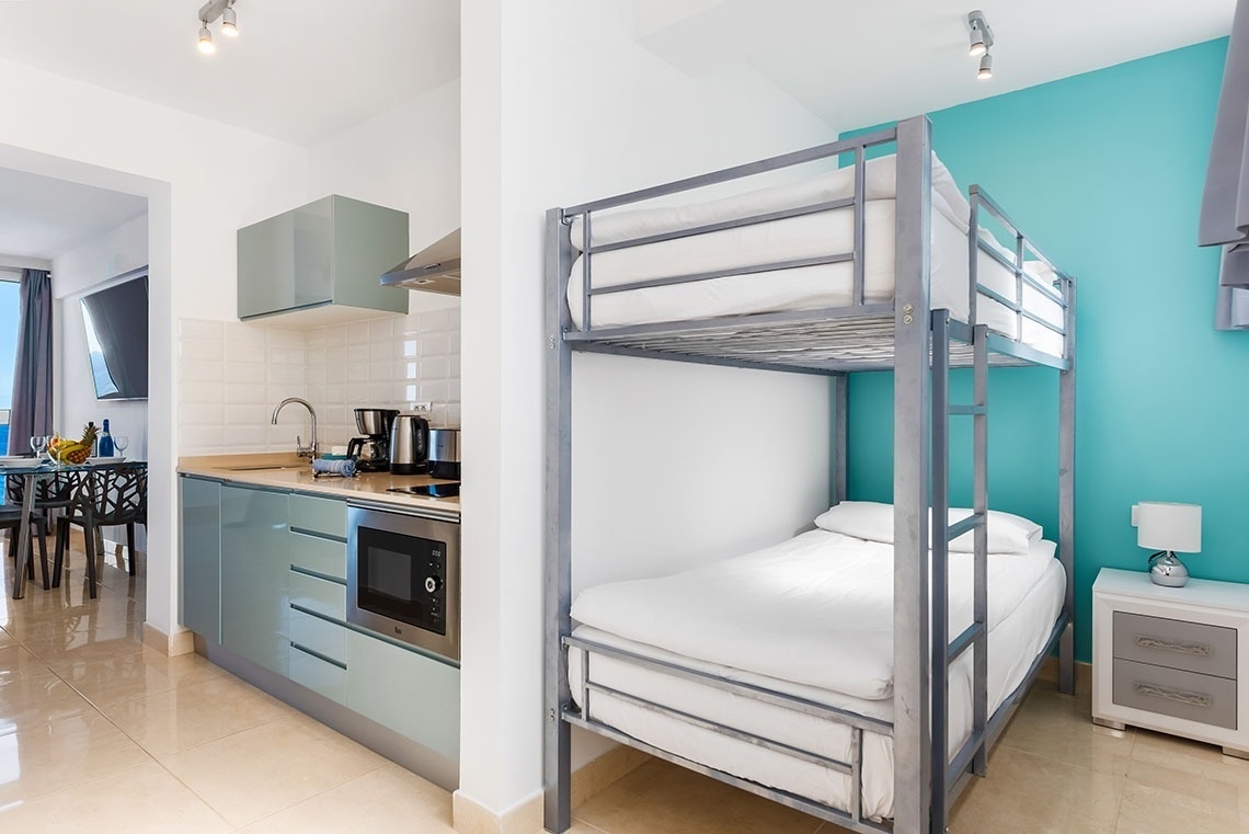 una stanza con due letti a castello e una cucina