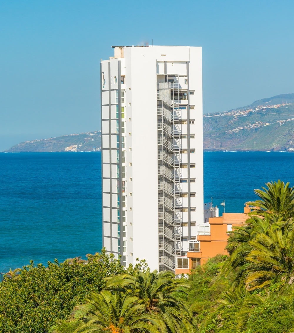 un balcón con hamaca y sillas y un paraguas