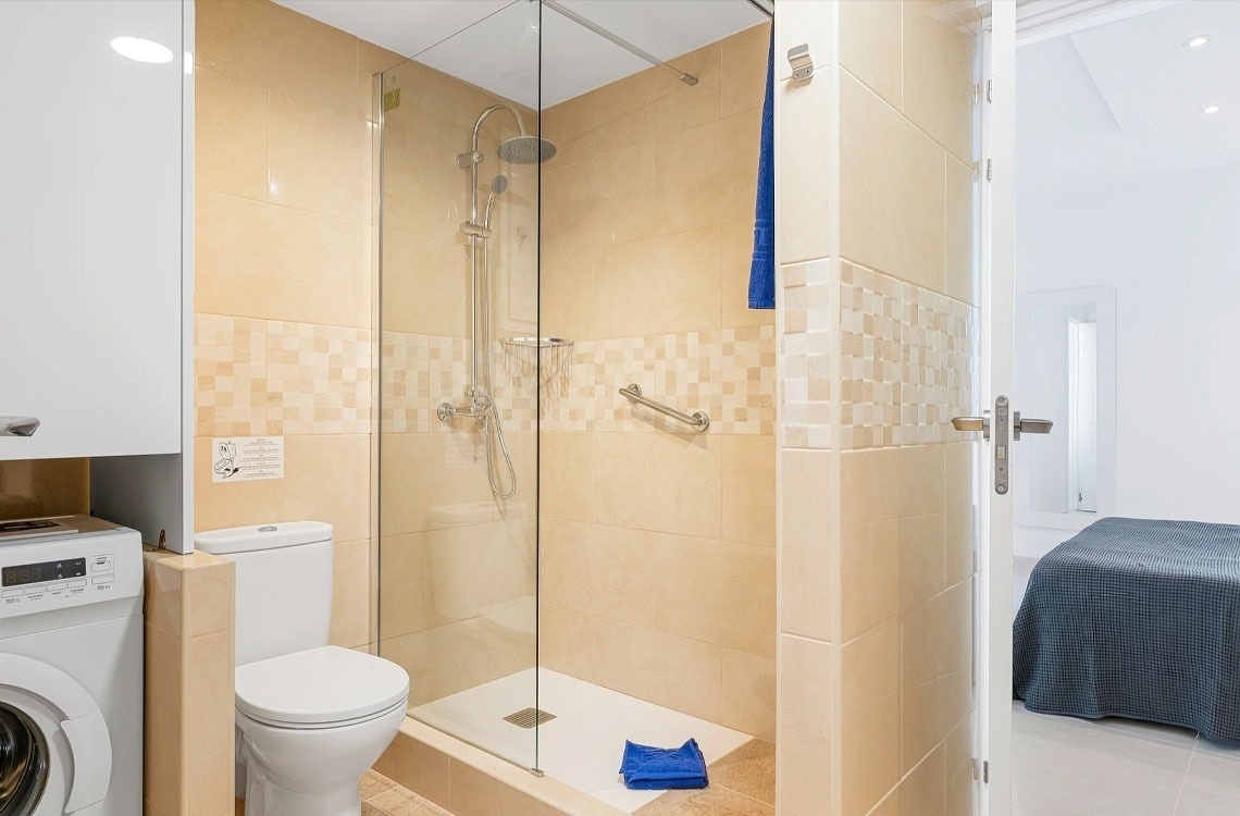 un bagno con doccia e wc e una lavatrice